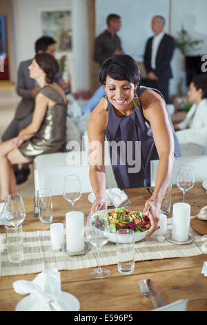 Servir des aliments femme at dinner party Banque D'Images