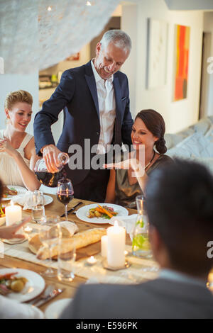 Le service du vin l'homme at dinner party Banque D'Images