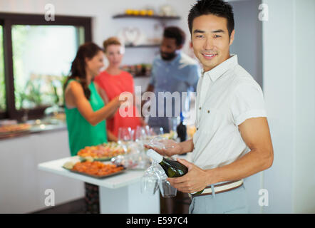 Homme portant une bouteille de vin at party Banque D'Images