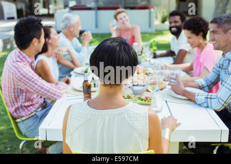 Amis parler à table outdoors Banque D'Images
