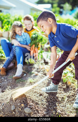 Garçon de retourner le sol au jardin Banque D'Images