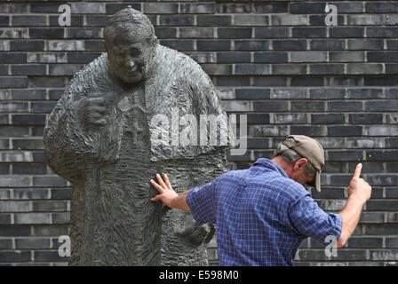 Hambourg, Allemagne. 24 juillet, 2014. Un travailleur donne durant le placement de la statue en bronze de Jean Paul II à Hambourg, Allemagne, 24 juillet 2014. La statue du pape Saint Jean Paul II a une nouvelle maison à St Mary's Cathedral. Photo : AXEL HEIMKEN/dpa/Alamy Live News Banque D'Images