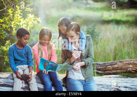 Les élèves et le professeur reading map in forest Banque D'Images