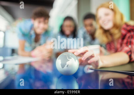 Personnes examinant globe miniature Banque D'Images