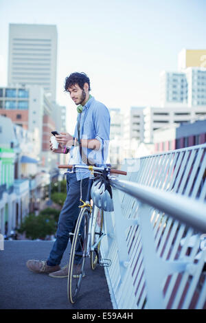 Man using cell phone on city street Banque D'Images