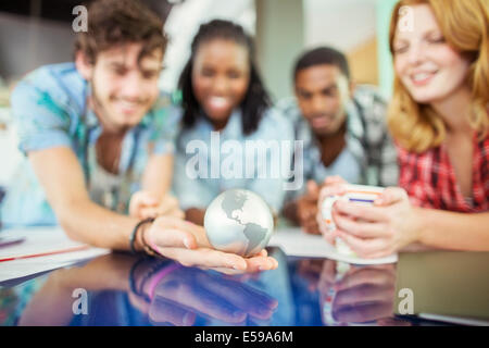 Personnes examinant globe in office Banque D'Images