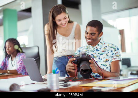 Les gens l'examen de photos ensemble in office Banque D'Images
