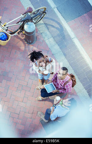 Des amis à l'aide de digital tablet on city street Banque D'Images