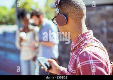 Man listening to mp3 player outdoors Banque D'Images