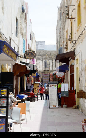 ESSAOUIRA, MAROC - 14 MAI 2014 : les femmes berbères locaux marche dans rue commerçante avec restaurant en scène. Essaouira, Maroc. Banque D'Images