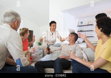 Les amis cheering at party Banque D'Images