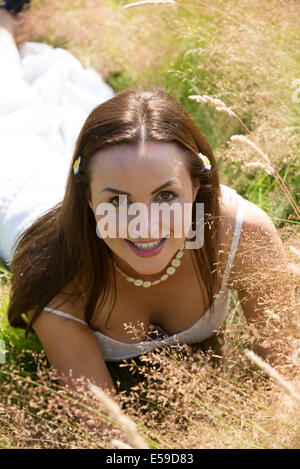 Portrait d'une jeune femme allongée sur l'herbe Banque D'Images