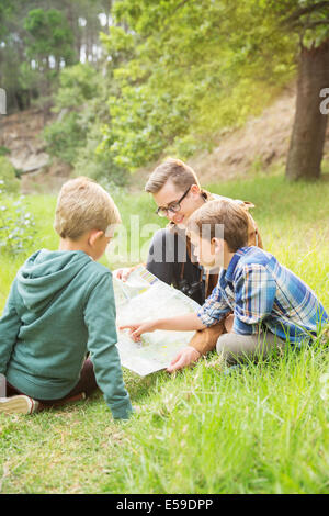 Les élèves et le professeur reading map in field Banque D'Images