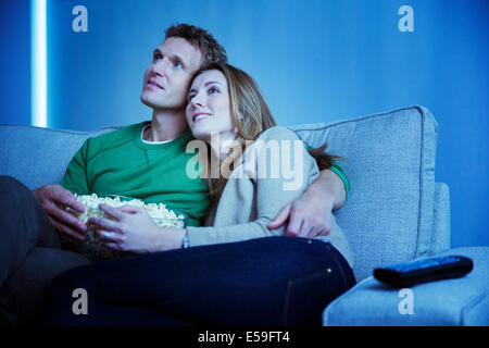 Couple watching television on sofa Banque D'Images