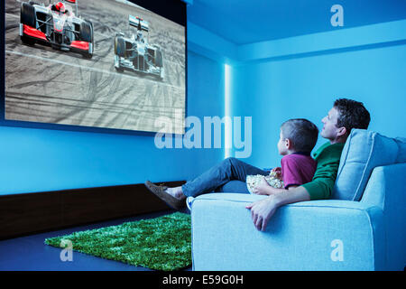 Père et fils à regarder la télévision dans la salle de séjour Banque D'Images