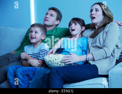 Regarder la télévision en famille dans la salle de séjour Banque D'Images