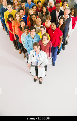 Médecin debout devant la foule diversifiée Banque D'Images