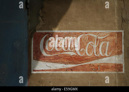 Old weathered logo Coca Cola peint sur un mur. Place une usine d'embouteillage de Tychy, Pologne. Banque D'Images