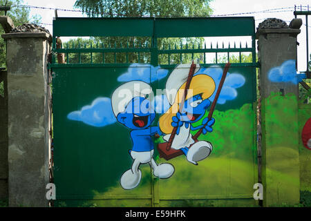 Photo de figurines peintes sur green metal gate. Banque D'Images