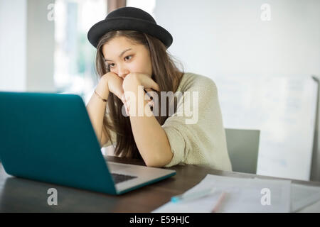 Woman working at laptop in office Banque D'Images