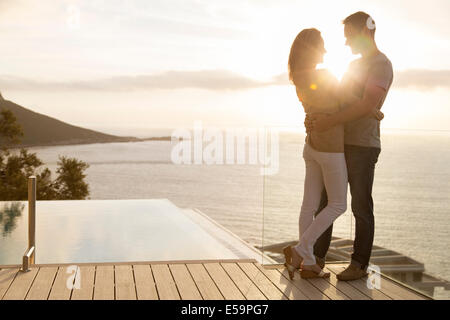 Couple sur une terrasse en bois donnant sur l'océan Banque D'Images