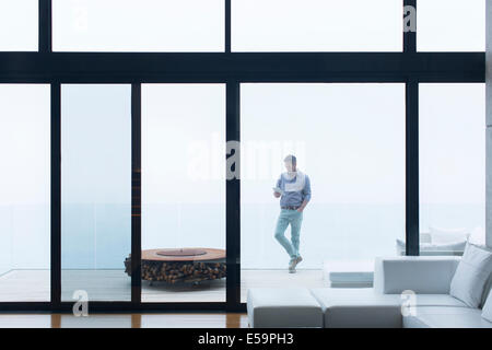 Man using cell phone on balcon moderne Banque D'Images