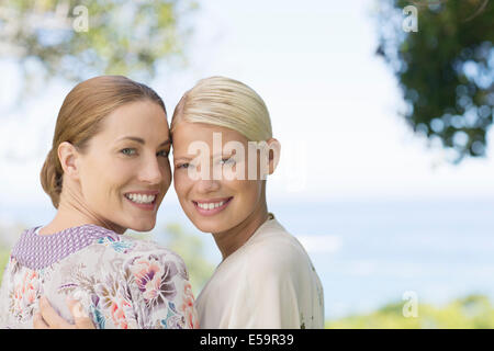 Smiling women hugging indoors Banque D'Images