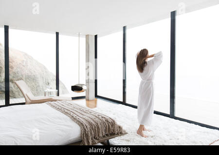 Femme portant un peignoir dans la chambre à coucher moderne Banque D'Images