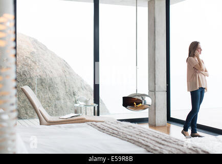 Woman talking on cell phone in modern bedroom Banque D'Images