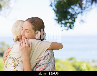 Women hugging outdoors Banque D'Images