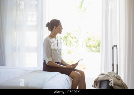 Businesswoman using digital tablet in hotel room Banque D'Images