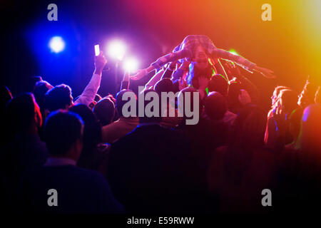 Woman crowd surfing au concert Banque D'Images