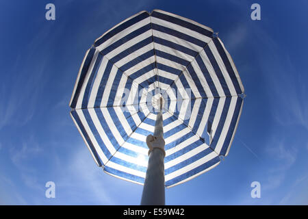 Parasol à rayures contre le ciel bleu Banque D'Images