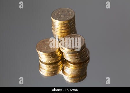 Devise britannique - colonnes de pièces livre, reflétée dans un miroir. Banque D'Images