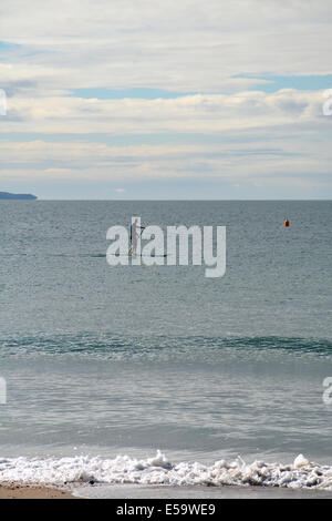 Man Stand Up Paddle Surf près de la plage de Takapuna avec la péninsule de Coromandel dans l'arrière-plan, Auckland, Nouvelle-Zélande Banque D'Images