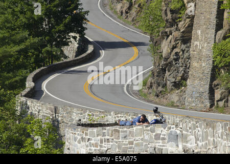 Ville de Deerpark, New York, USA. 24 juillet, 2014. Un motocycliste sur une paroi rocheuse et prend de l'avis sur le Hawk's Nest section de la Route 97 dans la ville de Deerpark, New York. Cette section de route de torsion, situé à des centaines de pieds au-dessus de la rivière Delaware, a été fréquemment utilisées dans des spots publicitaires et des publicités et fait partie de la partie supérieure de la Florida Scenic Byway. Crédit : Tom Bushey/ZUMA/Alamy Fil Live News Banque D'Images