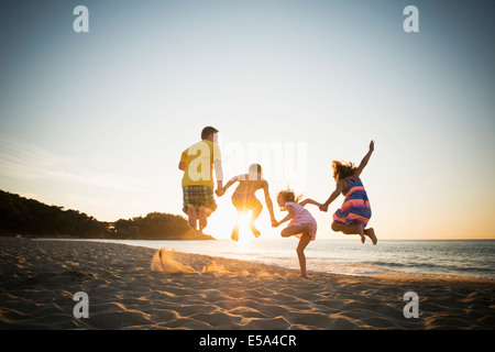 Family jumping for joy on beach