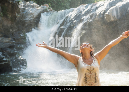 Hispanic woman standing by waterfall Banque D'Images