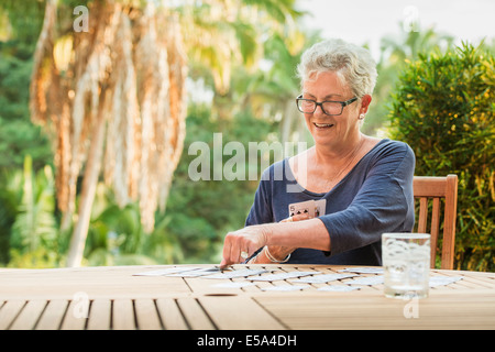 Caucasian woman cartes à jouer à l'extérieur Banque D'Images