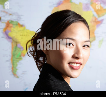 Chinese businesswoman standing par carte du monde Banque D'Images