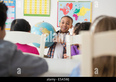 Boy showing globe pour classe Banque D'Images