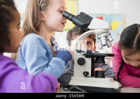 Les élèves à l'aide de microscope in classroom Banque D'Images