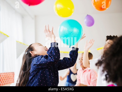 Les enfants qui jouent avec des ballons colorés at party Banque D'Images