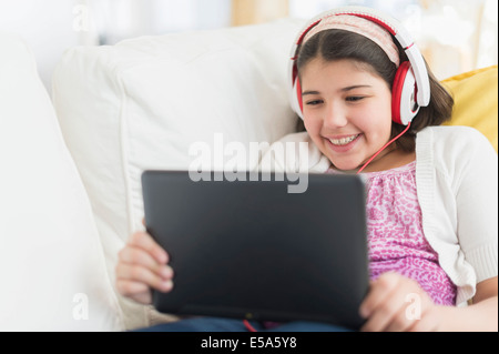 Hispanic girl sitting on sofa Banque D'Images