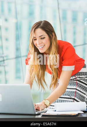 Mixed Race businesswoman working at desk Banque D'Images