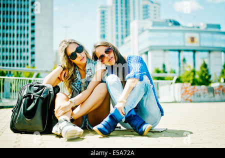 Women sitting on city street Banque D'Images