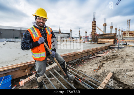 Black worker smiling at construction site Banque D'Images