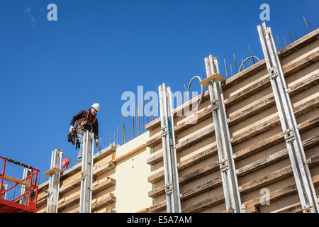 Caucasian worker marche sur mur de béton forme Banque D'Images