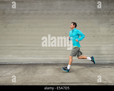 Caucasian man running on city street Banque D'Images