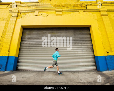 Caucasian man running on city street Banque D'Images